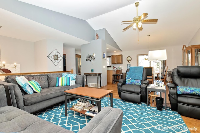 living room featuring ceiling fan, lofted ceiling, and hardwood / wood-style flooring