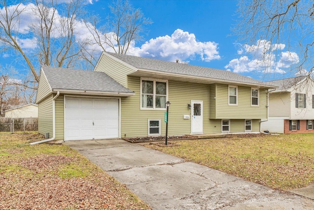 split foyer home with a garage and a front lawn