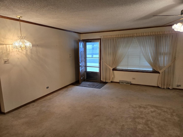 unfurnished room with a textured ceiling, carpet floors, ceiling fan, and ornamental molding