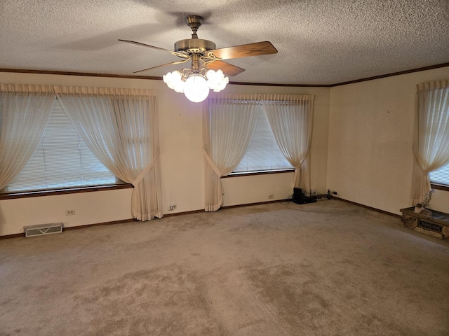 spare room with a textured ceiling, ceiling fan, and a healthy amount of sunlight