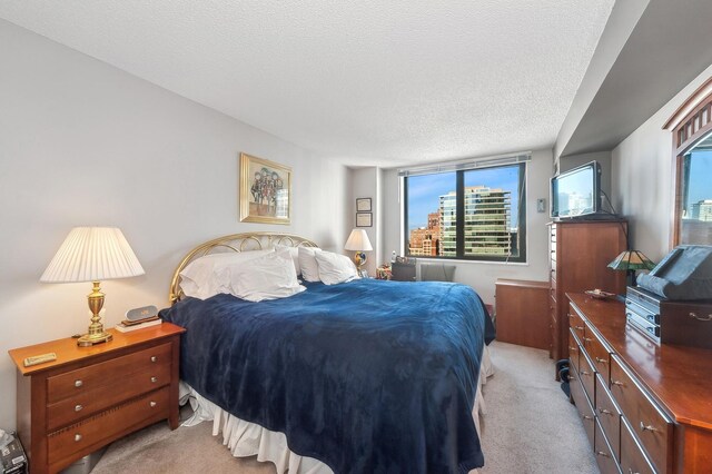 bedroom featuring a textured ceiling and light carpet