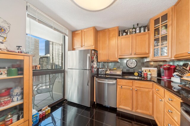 kitchen with sink, stainless steel appliances, backsplash, and a textured ceiling