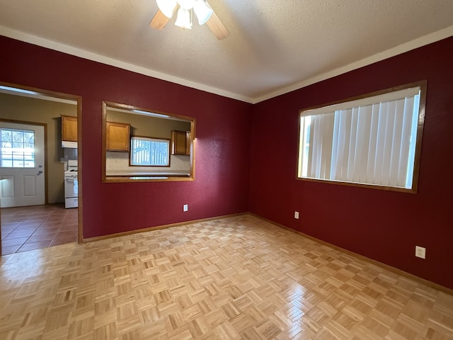 empty room featuring ceiling fan, a textured ceiling, and light parquet flooring