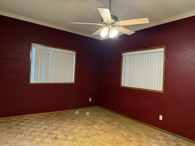 empty room with light parquet floors and ceiling fan