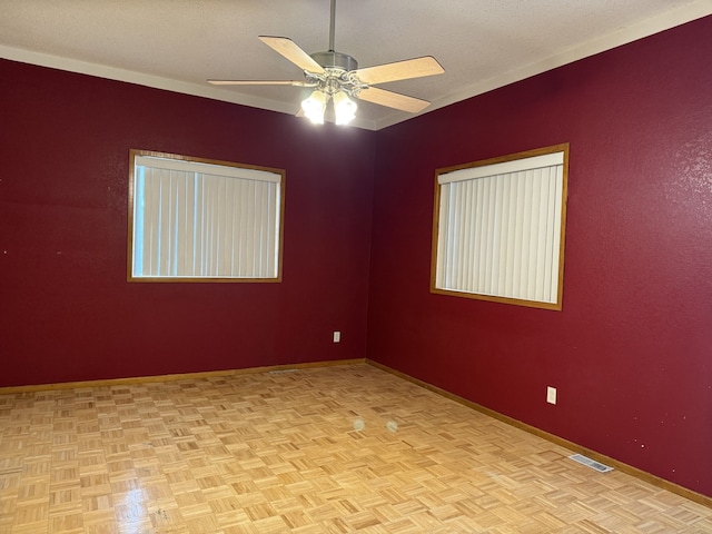 unfurnished room with ceiling fan and light parquet floors