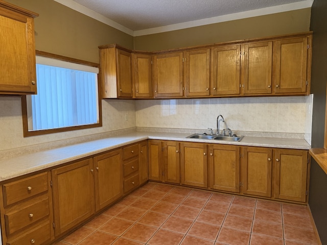 kitchen with a textured ceiling, light tile patterned flooring, sink, and tasteful backsplash