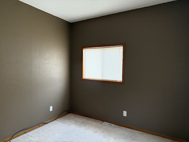 unfurnished room featuring light carpet