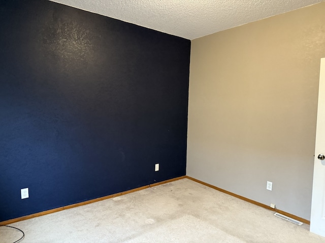 empty room with carpet and a textured ceiling