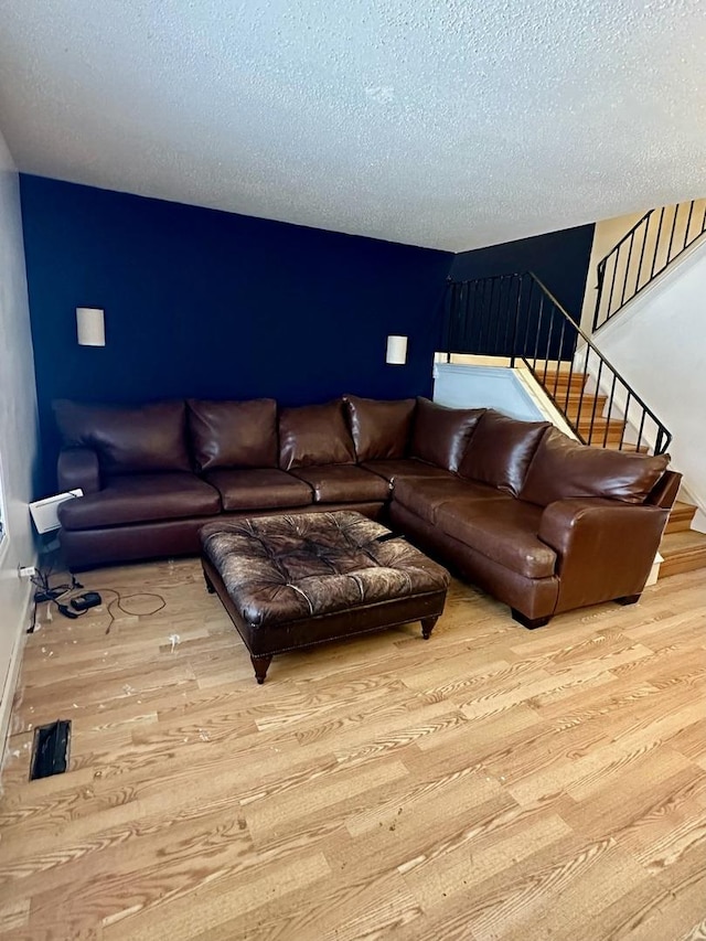 living room featuring light hardwood / wood-style flooring and a textured ceiling