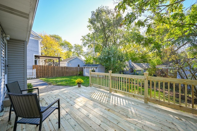 wooden terrace featuring a lawn and a storage unit