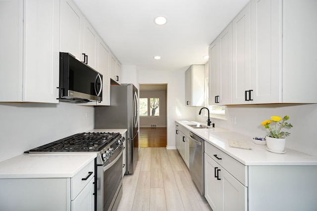 kitchen with white cabinetry, stainless steel appliances, and sink