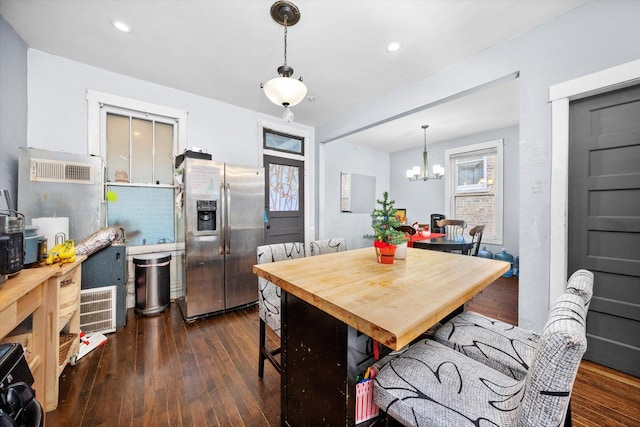 dining area with dark hardwood / wood-style floors and an inviting chandelier