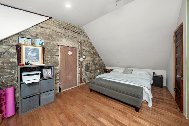 bedroom with wood-type flooring and vaulted ceiling