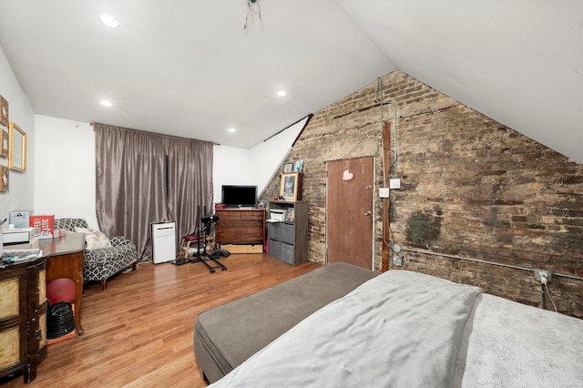 bedroom with light hardwood / wood-style flooring and lofted ceiling