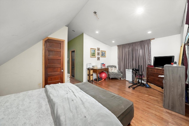 bedroom with lofted ceiling and light wood-type flooring