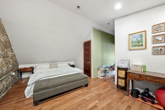 bedroom with hardwood / wood-style floors and lofted ceiling