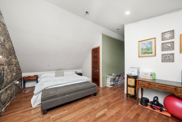 bedroom featuring hardwood / wood-style floors and lofted ceiling