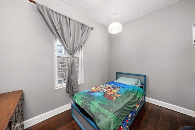 bedroom featuring a textured ceiling and dark hardwood / wood-style floors