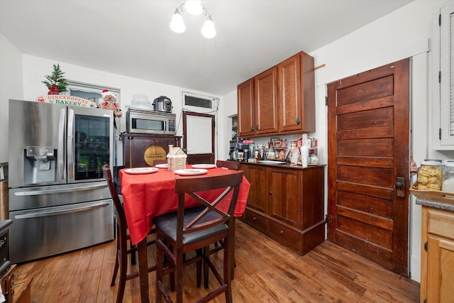 kitchen featuring hardwood / wood-style floors, a notable chandelier, and appliances with stainless steel finishes