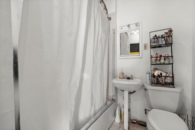 bathroom featuring tile patterned flooring, toilet, and shower / tub combo