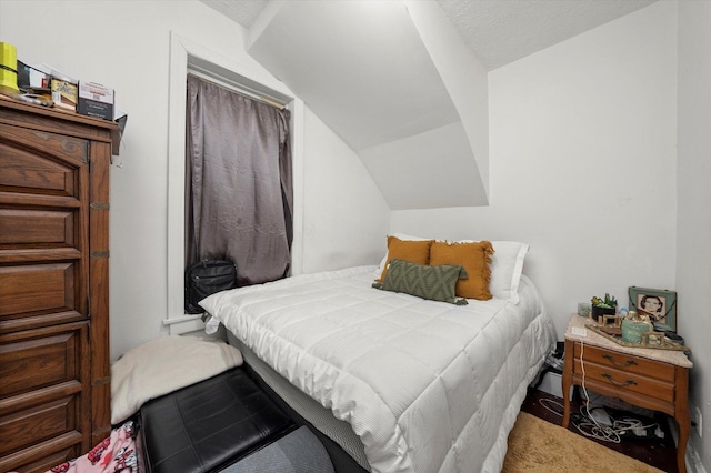 bedroom featuring carpet flooring, lofted ceiling, and a textured ceiling