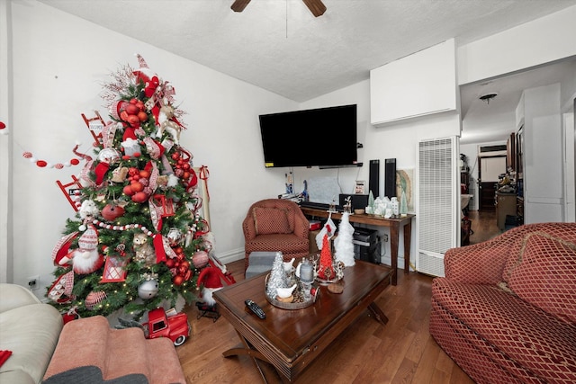 living room featuring hardwood / wood-style flooring, ceiling fan, and a textured ceiling