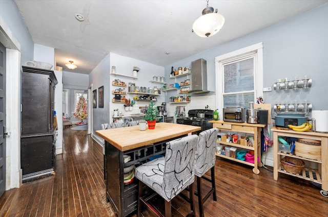 kitchen featuring black range with gas stovetop, dark hardwood / wood-style floors, and wall chimney exhaust hood