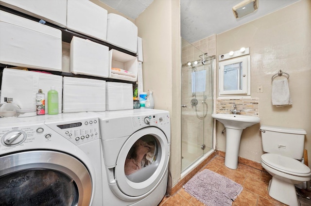 laundry room featuring light tile patterned floors, separate washer and dryer, and sink