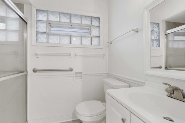 bathroom with toilet, vanity, and walk in shower