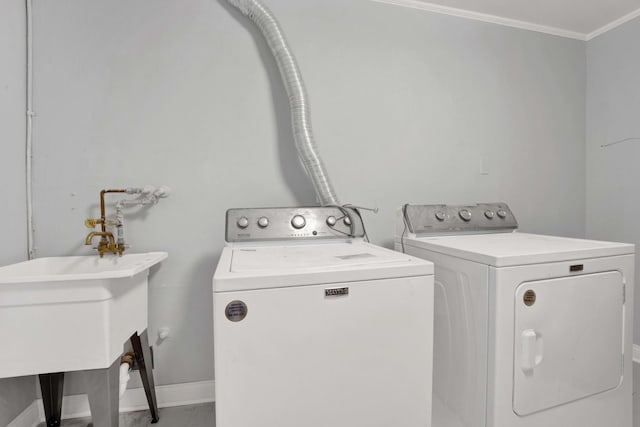 laundry room featuring washing machine and dryer, sink, and ornamental molding