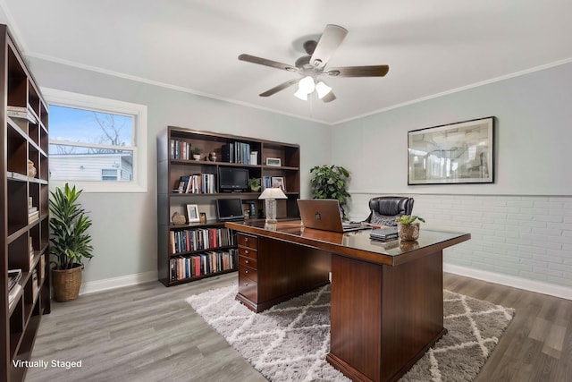 office area featuring hardwood / wood-style floors, ceiling fan, crown molding, and brick wall