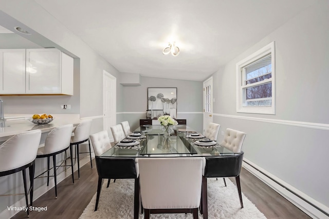 dining space with hardwood / wood-style flooring, lofted ceiling, and baseboard heating