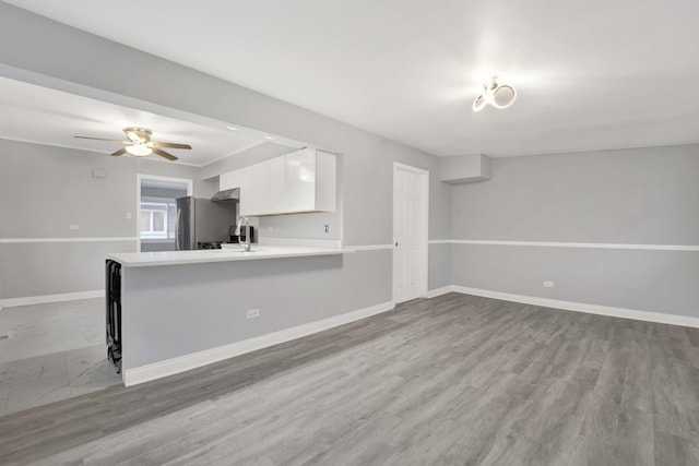 unfurnished living room with ceiling fan, light hardwood / wood-style flooring, and sink