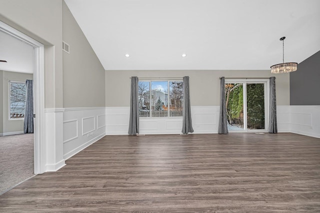 interior space with dark hardwood / wood-style floors, an inviting chandelier, and lofted ceiling