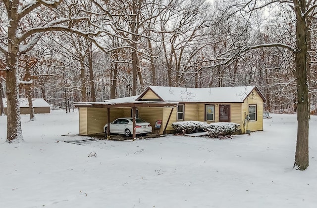 snow covered parking featuring a carport