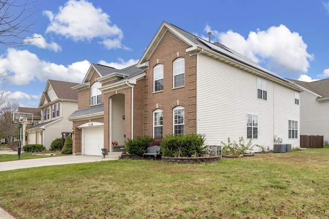 front facade featuring solar panels, cooling unit, a front yard, and a garage