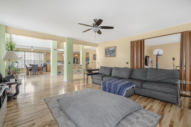 living room featuring light wood-type flooring and ceiling fan