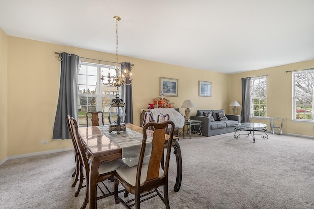 carpeted dining space featuring a notable chandelier and a wealth of natural light