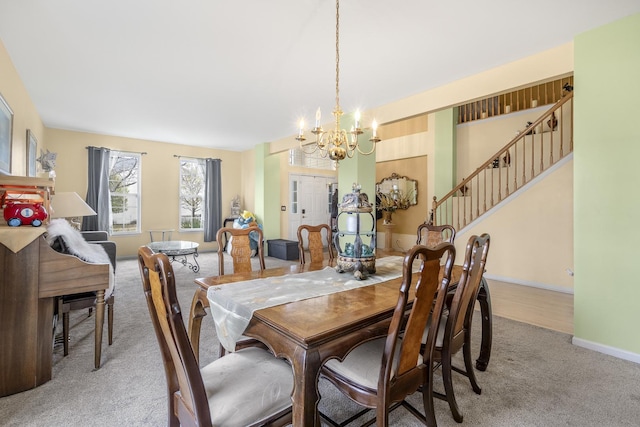 carpeted dining area with an inviting chandelier