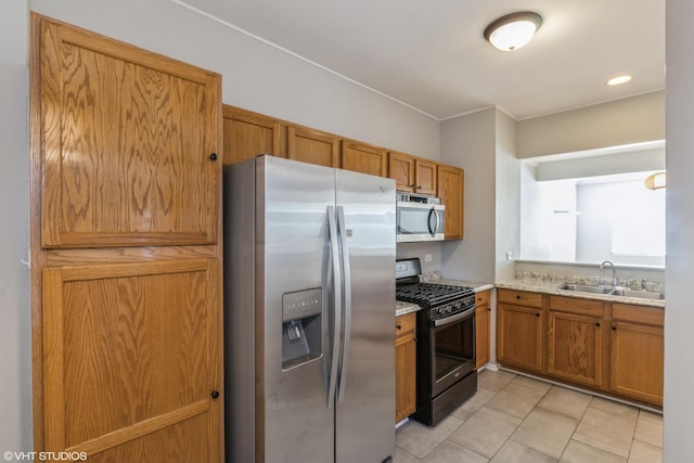 kitchen with appliances with stainless steel finishes, light tile patterned floors, and sink