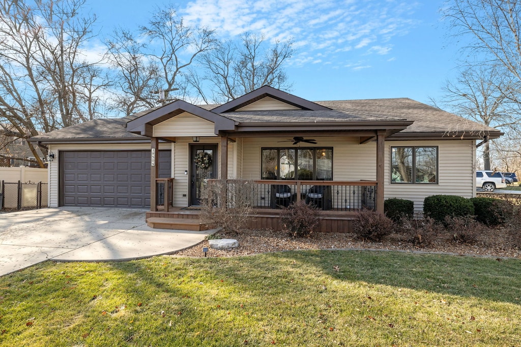 single story home featuring ceiling fan, a garage, covered porch, and a front yard