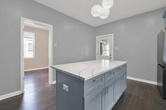 kitchen featuring a chandelier, dark hardwood / wood-style flooring, a kitchen island, and hanging light fixtures