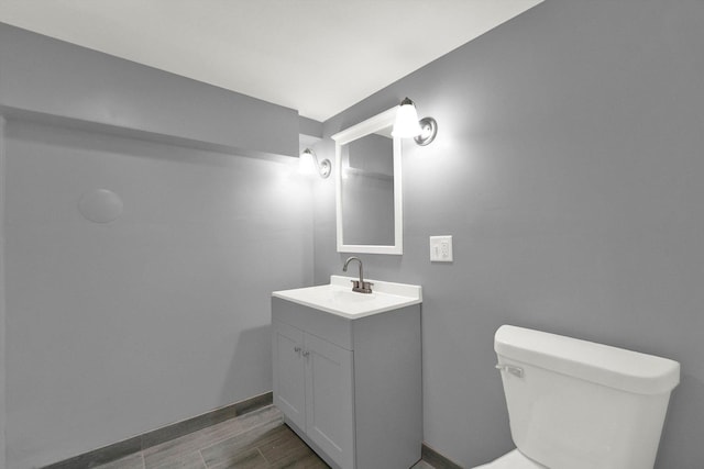 bathroom featuring wood-type flooring, vanity, and toilet