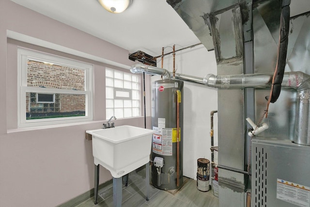 utility room featuring gas water heater and sink