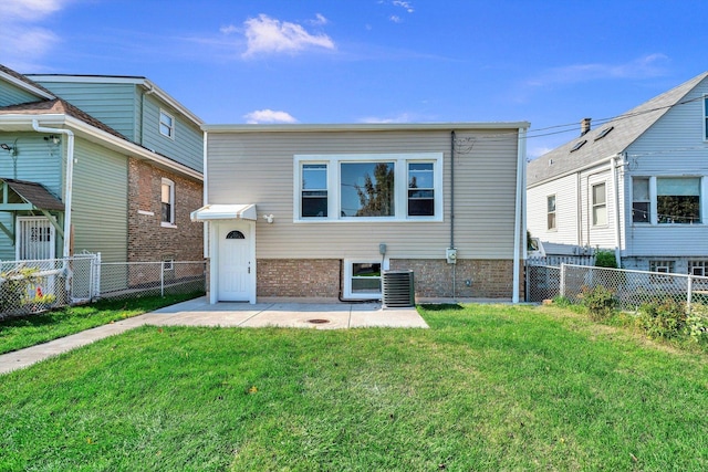 rear view of property with central AC unit and a lawn