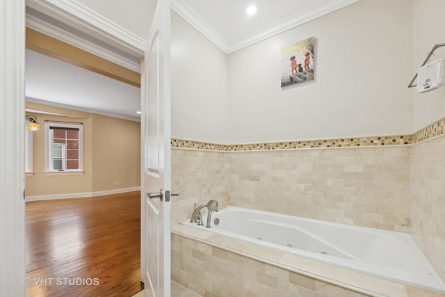 bathroom featuring hardwood / wood-style floors, tiled tub, and ornamental molding