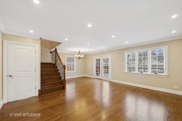 unfurnished living room with dark hardwood / wood-style flooring, a chandelier, plenty of natural light, and crown molding