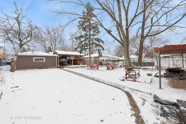 yard covered in snow featuring an outbuilding