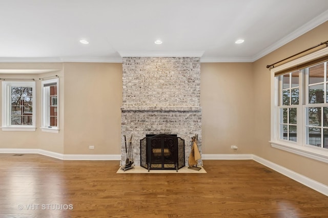 unfurnished living room featuring a fireplace, ornamental molding, and hardwood / wood-style flooring