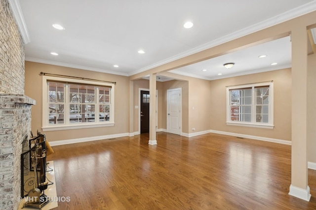 unfurnished living room with a fireplace, hardwood / wood-style flooring, and crown molding